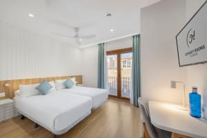 sypialnia z łóżkiem, biurkiem i oknem w obiekcie Odyssey Rooms Alicante w Alicante