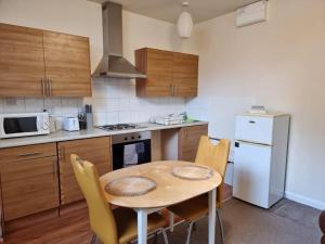 a kitchen with a table and chairs in a kitchen at Loliz Pamper palace in Nottingham