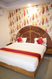 una camera con un grande letto con testiera in legno di Hotel Signor a Indore