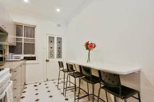 a kitchen with a counter with chairs and a vase of flowers at Affordable 3 Bedroom House Darlinghurst with 2 E-Bikes Included in Sydney