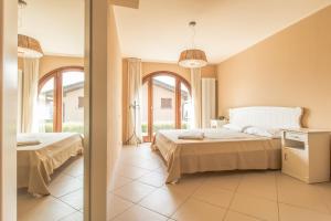a bedroom with two beds and two windows at Il Borgo Apartment Menaggio in Menaggio +12 photos