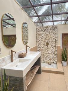ein Bad mit einem Waschbecken und 2 Spiegeln in der Unterkunft Gading Tree House in Nusa Penida