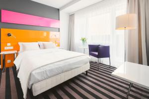 Habitación de hotel con cama y escritorio en Hola Hotel Katowice, en Katowice