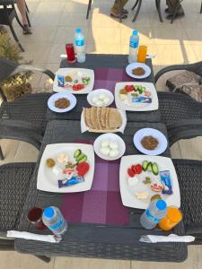 a table with plates of food and drinks on it at Hur magic pyramids Hotel in Cairo