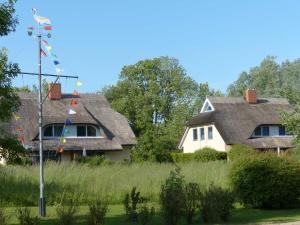 a house with flags in front of it at Behagliches Reetdachhaus Eibe 1 in Puddemin