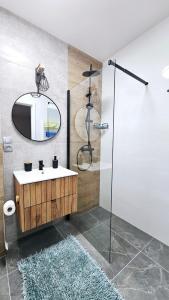 a bathroom with a sink and a shower with a mirror at Kolo Apartament in Koło