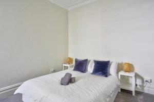 1 dormitorio con cama blanca y almohadas azules en Unique 2 Bedroom Darling Harbour Glebe 2 E-Bikes Included en Sídney