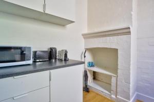 a kitchen with a microwave and a brick oven at Unique 2 Bedroom Darling Harbour Glebe 2 E-Bikes Included in Sydney