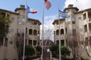 dos banderas están volando delante de un edificio en 3107 The Island, en Lago Vista 36 fotos más