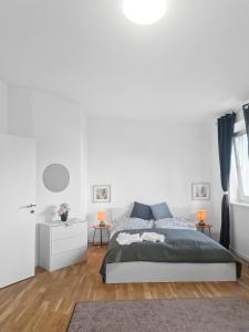 Dormitorio blanco con cama y pared blanca en Brodschildstraße apartment, en Stockerau