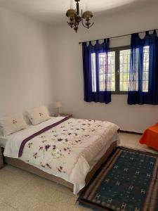 - une chambre avec un lit doté de rideaux bleus dans l'établissement Dar dguech, à Degache