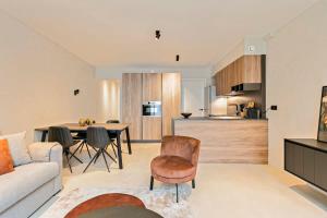 ein Wohnzimmer und eine Küche mit einem Sofa und einem Tisch in der Unterkunft New and highly unique apartment with private parking in Knokke-Heist