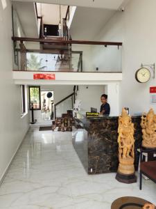 a man sitting at a counter in a room at Seed Resort in Shrīrangapattana