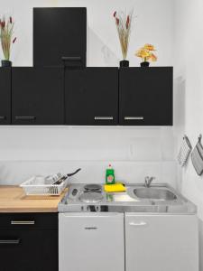 a kitchen with black and white cabinets and a sink at Brodschildstraße apartment in Stockerau