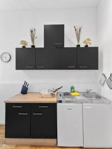 a kitchen with black and white cabinets and a sink at Brodschildstraße apartment in Stockerau