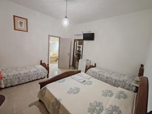 a bedroom with two beds and a flat screen tv at Zia Mia B&b in Olbia
