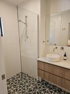 a white bathroom with a sink and a shower at Winterlude Cottage in Orange
