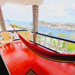a hammock on a balcony with a view of the water at Carenage Ocean View in DʼArbeau