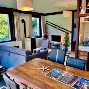 uma sala de estar com uma mesa de madeira e cadeiras em Chalet la Pagode, vue Mont-Blanc et jardin privé em Chamonix-Mont-Blanc
