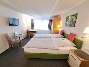 ein Hotelzimmer mit einem großen Bett und einem Schreibtisch in der Unterkunft Gasthaus Zum Lindenwirt in Weißehütte