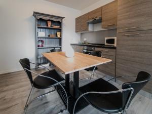 a kitchen with a wooden table and black chairs at L'Albatros in Le Tréport