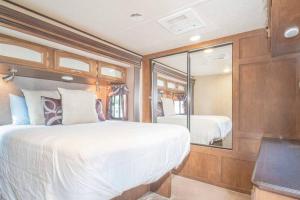 ein Schlafzimmer mit einem großen Bett und einem Spiegel in der Unterkunft Moab RV Resort RV IV Fully Setup OK44 in Moab