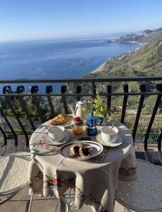 a table with food and a view of the ocean at The breath from The soul in Forza dʼAgro