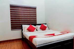 Un dormitorio con una cama con almohadas rojas. en pookode villa, en Vythiri