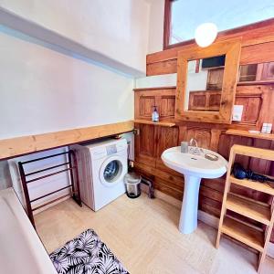 a bathroom with a sink and a washing machine at Chalet la Pagode, vue Mont-Blanc et jardin privé in Chamonix-Mont-Blanc