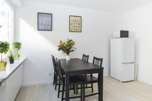 a dining room with a black table and a white refrigerator at 2: Schöne Schwabing 70m² sannierte City Wohnung in Munich