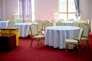 a row of tables and chairs in a room at Zhingkham Cottages in Thimphu