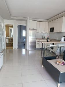 a large kitchen with white cabinets and a table at SEA VIEW APARTMENTS in Costa Calma