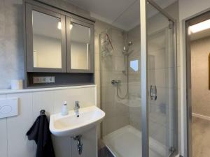 a bathroom with a shower and a sink and a shower at Windfang 2 in Hooksiel in Wangerland
