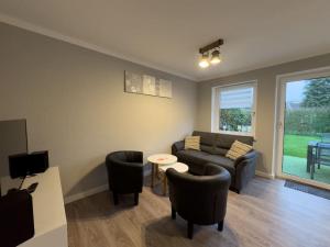 a living room with a couch and chairs and a table at Windfang 2 in Hooksiel in Wangerland