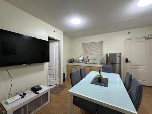 a living room with a table and a flat screen tv at Sanremo Oasis, City di Mare, SRP in Cebu City