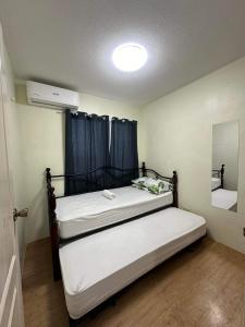 a bedroom with two beds in a room with a mirror at Sanremo Oasis, City de Mare in Cebu City