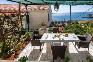 una mesa blanca y sillas en un patio con vistas al océano en Apartment Flora, en Dubrovnik