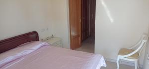 a bedroom with a bed and a chair and a door at Apartamet Benidorm in Benidorm