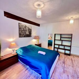 sypialnia z niebieskim łóżkiem i drewnianą podłogą w obiekcie Chalet la Pagode, vue Mont-Blanc et jardin privé w Chamonix-Mont-Blanc