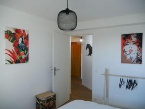 a bedroom with a bed and a pendant light at ARSAV Vue Mer et Plage in Port-Louis