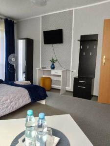 1 dormitorio con 1 cama y 1 mesa con botellas de agua en Camping Bystry, en Giżycko