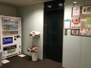 einen Kühlschrank mit einer Blume in einer Vase daneben. in der Unterkunft Hotel Green Palace in Sendai