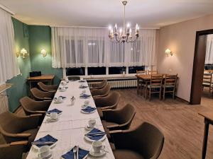 Pension Waltermann في Balve: غرفة طعام كبيرة مع طاولة وكراسي طويلة