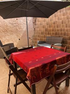 Chez Aldo في أجاكسيو: طاولة حمراء مع كراسي ومظلة
