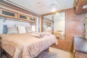 a bedroom with a large bed and a mirror at Moab RV Resort RV Fully Setup OK41 in Moab