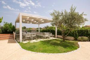 a table and chairs under a pavilion with a tree at Camere Relais Filomare in Marcelli