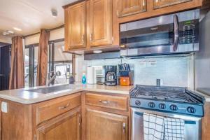 a kitchen with wooden cabinets and a stove top oven at Moab RV Resort RV Fully Setup OK41 in Moab