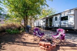 a group of chairs and a fire pit next to an rv at Moab RV Resort RV Fully Setup OK41 in Moab