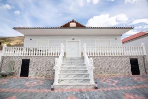 a white house with stairs in front of it at Luxury House in Korçë