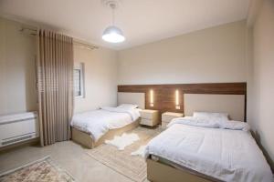 Un dormitorio con dos camas con sábanas blancas. en Luxury House, en Korçë